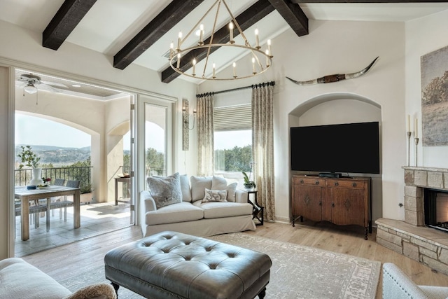 living area with high vaulted ceiling, beamed ceiling, a stone fireplace, and wood finished floors