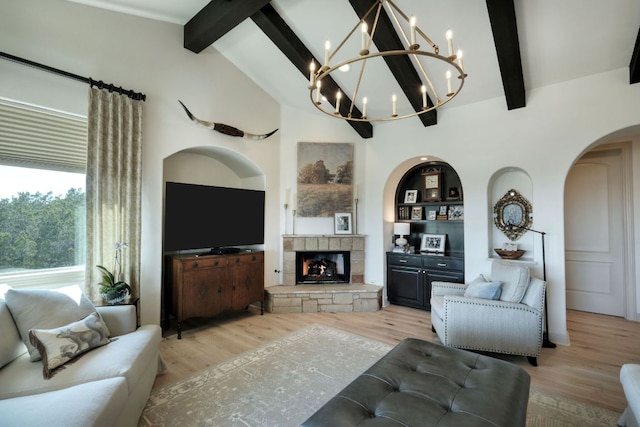 8205 Moon Rise Trl, Jonestown, TX 78645 - living area featuring arched walkways, light wood-type flooring, a chandelier, and a fireplace