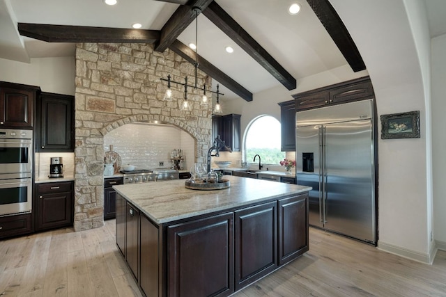 8205 Moon Rise Trl, Jonestown, TX 78645 - kitchen featuring appliances with stainless steel finishes, a kitchen island, light wood-style floors, backsplash, and recessed lighting