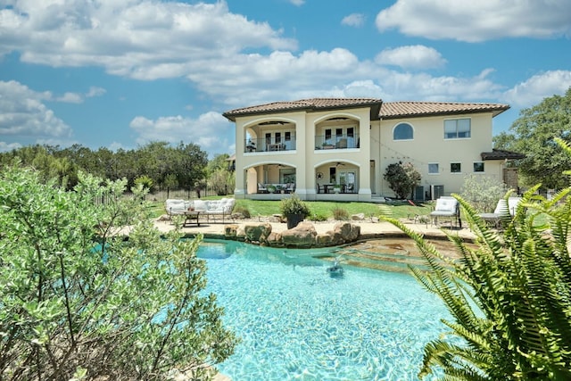 8205 Moon Rise Trl, Jonestown, TX 78645 - rear view of property with a patio area, an outdoor pool, stucco siding, a balcony, and a tile roof
