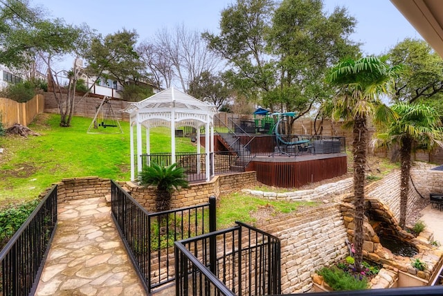 view of yard with a gazebo, a playground, and a fenced backyard