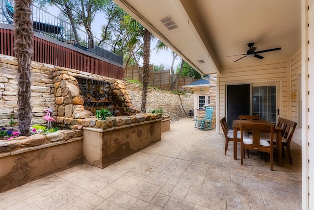 view of patio with outdoor dining space, fence, and ceiling fan