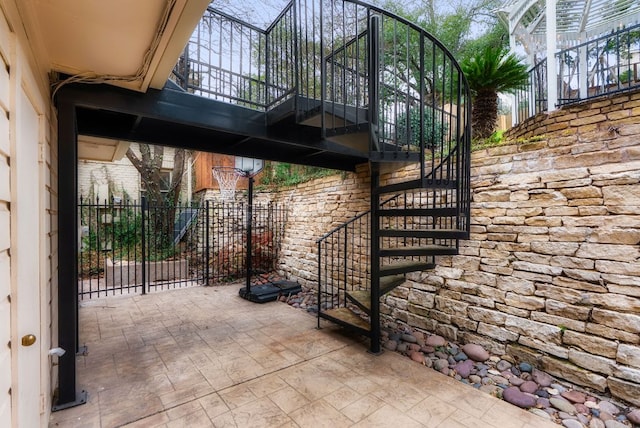 view of patio featuring stairway and fence