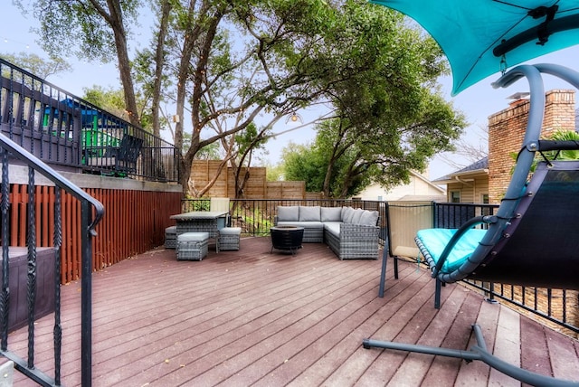 wooden terrace with an outdoor living space, stairway, and fence