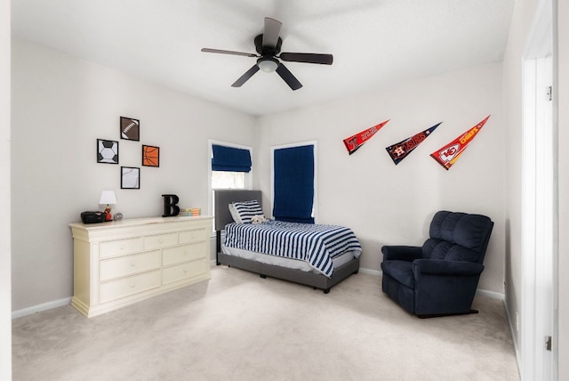 bedroom featuring light colored carpet, baseboards, and ceiling fan