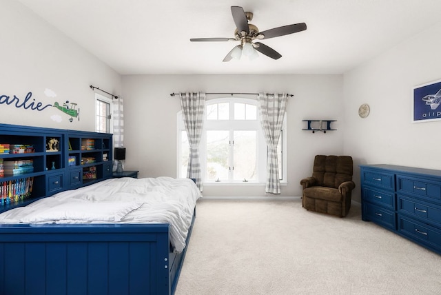 bedroom with a ceiling fan, light colored carpet, and baseboards