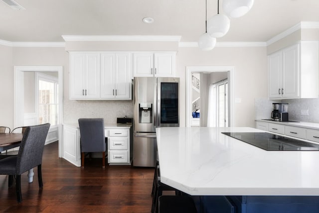 kitchen featuring black electric cooktop, visible vents, stainless steel fridge, and ornamental molding