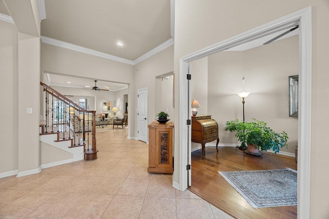 entrance foyer featuring ornamental molding, stairway, light tile patterned floors, baseboards, and ceiling fan