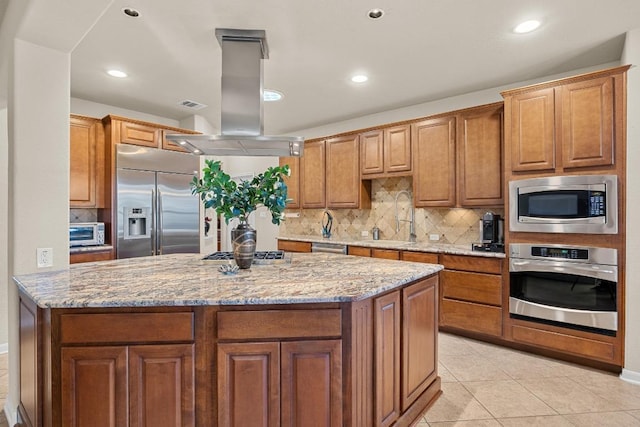 kitchen with built in appliances, brown cabinets, and a sink