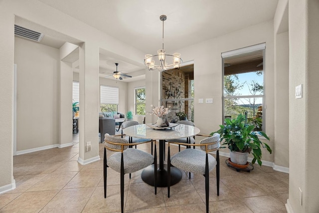 dining area with light tile patterned floors, ceiling fan with notable chandelier, visible vents, and baseboards