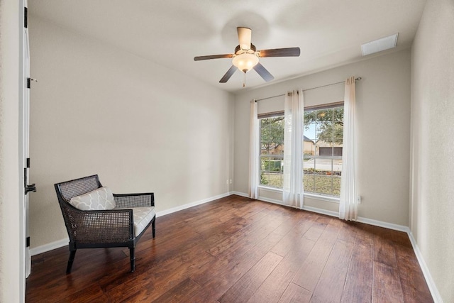 sitting room featuring visible vents, a ceiling fan, baseboards, and wood-type flooring