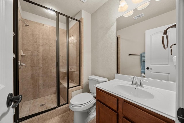 bathroom featuring visible vents, a shower stall, toilet, a textured wall, and vanity