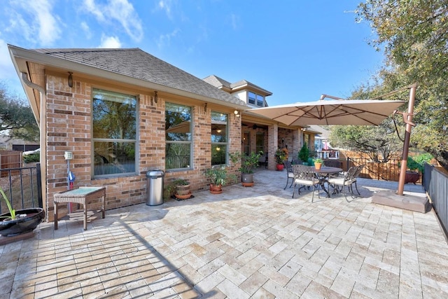 view of patio with outdoor dining space and fence