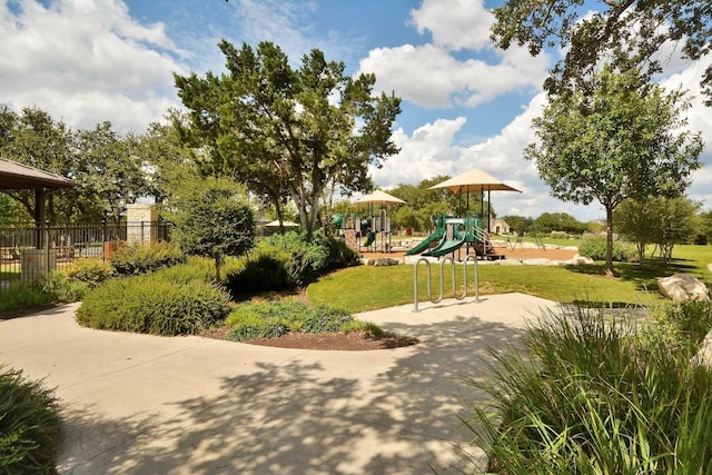 view of home's community featuring playground community, a yard, and fence