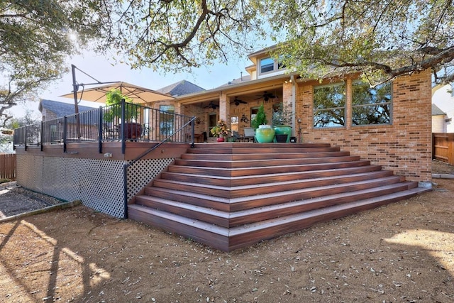 back of house with a ceiling fan, fence, stairway, a wooden deck, and brick siding