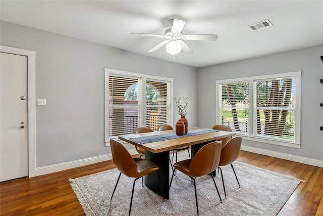 dining room featuring wood finished floors, visible vents, and baseboards