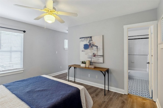 bedroom with ceiling fan, ensuite bath, baseboards, and wood finished floors