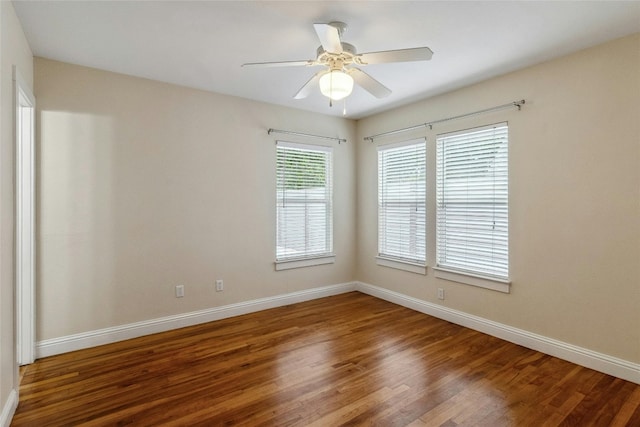 spare room featuring a ceiling fan, baseboards, and wood finished floors