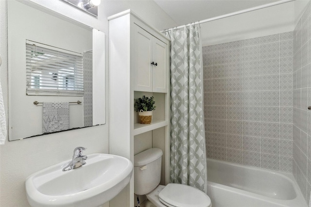 bathroom with a sink, toilet, and shower / tub combo with curtain