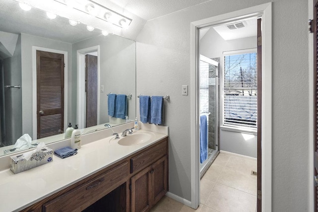 bathroom featuring visible vents, a shower stall, baseboards, tile patterned floors, and vanity