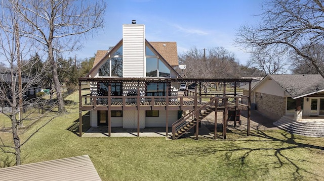 rear view of house featuring a lawn, stairway, a wooden deck, a chimney, and a patio area