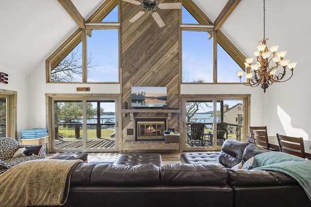 living room with a glass covered fireplace, beam ceiling, ceiling fan with notable chandelier, and wood finished floors