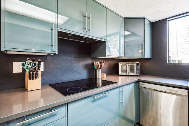 kitchen featuring under cabinet range hood, black electric cooktop, stainless steel dishwasher, and a textured ceiling