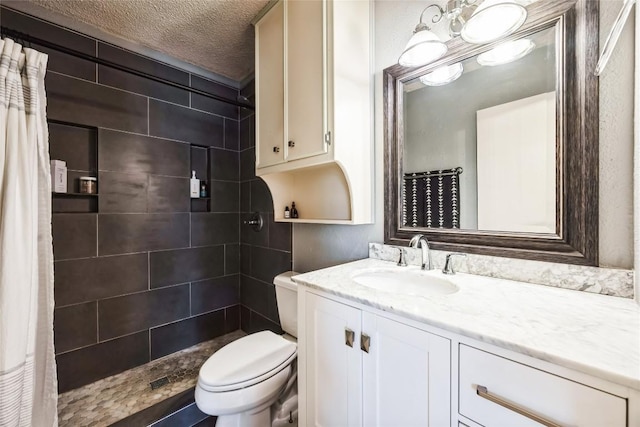 full bath with vanity, a textured ceiling, toilet, and tiled shower