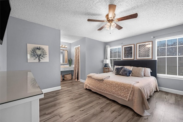 bedroom featuring multiple windows, wood finished floors, and baseboards