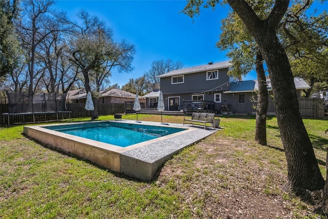 view of swimming pool with a fenced in pool, a trampoline, a fenced backyard, and a yard