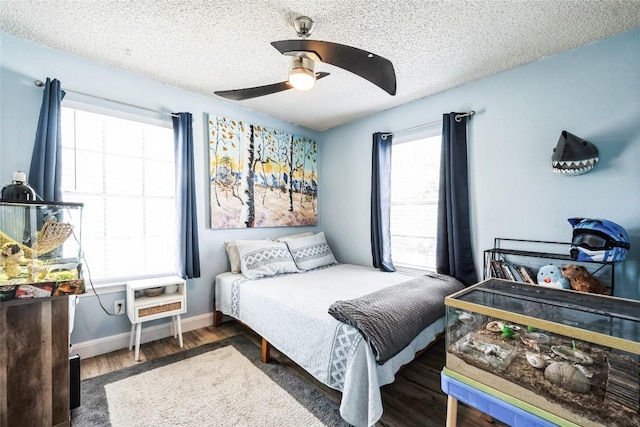 bedroom featuring a textured ceiling, a ceiling fan, baseboards, and wood finished floors