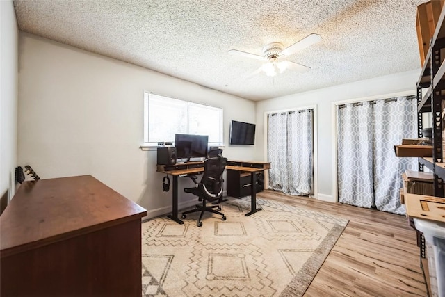 office with a textured ceiling, wood finished floors, baseboards, and ceiling fan