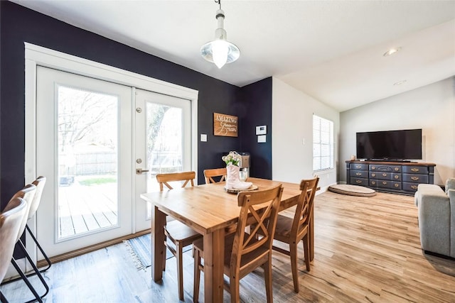 dining space featuring french doors, lofted ceiling, and wood finished floors