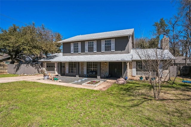 view of front of house with a front yard, fence, driveway, roof with shingles, and covered porch