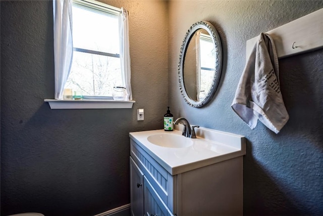 bathroom with vanity and a textured wall