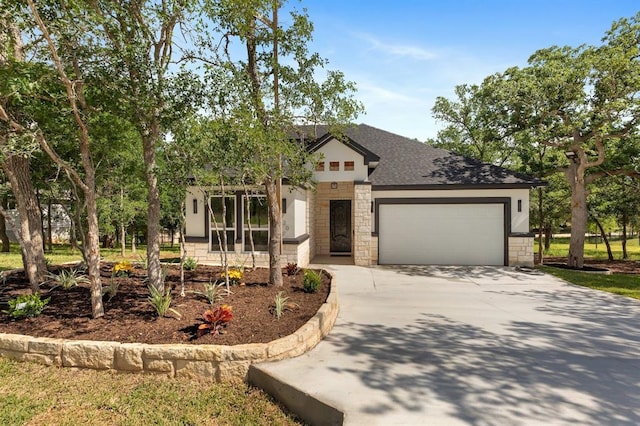 view of front of house with an attached garage, stone siding, driveway, and roof with shingles