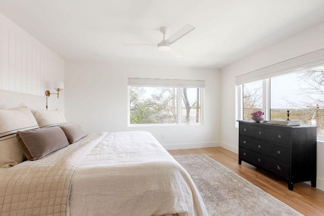 bedroom featuring ceiling fan, baseboards, and light wood-style flooring