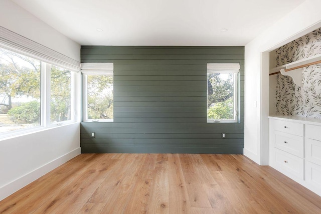 interior space with light wood-style flooring, plenty of natural light, and baseboards