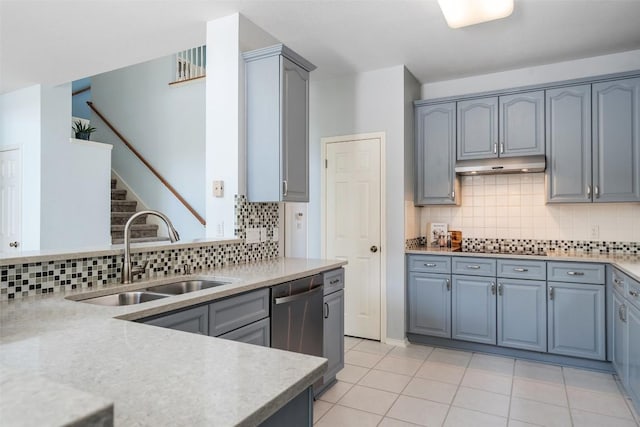 kitchen featuring tasteful backsplash, under cabinet range hood, dishwasher, light countertops, and a sink