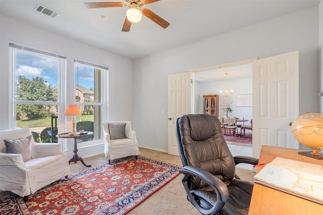 carpeted home office featuring visible vents, baseboards, and ceiling fan with notable chandelier