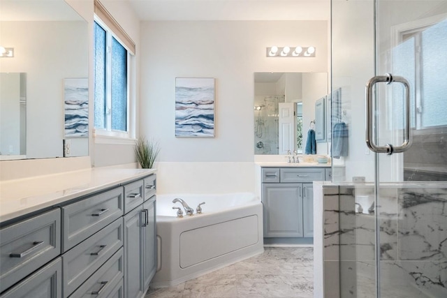 bathroom with a marble finish shower, marble finish floor, a bath, and vanity