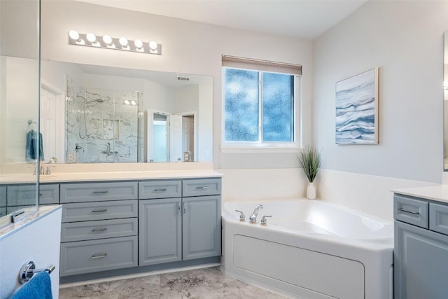 bathroom featuring a marble finish shower, marble finish floor, a bath, and vanity