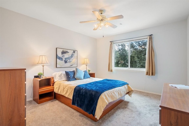 bedroom with a ceiling fan, baseboards, and light carpet