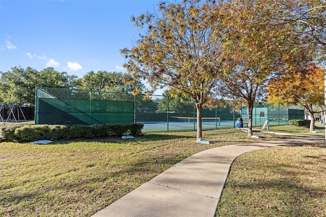 view of sport court with a lawn and fence