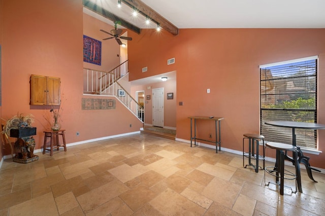 foyer featuring stairway, stone tile floors, baseboards, beam ceiling, and ceiling fan