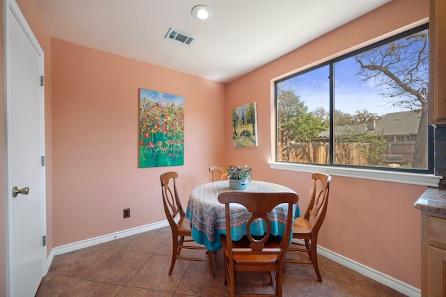 dining room featuring tile patterned floors, visible vents, and baseboards