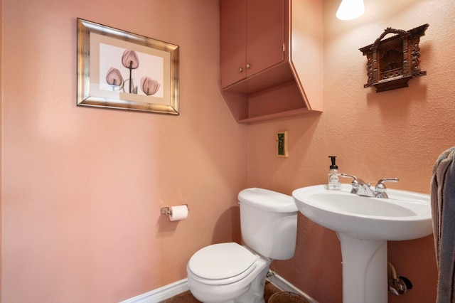 bathroom featuring toilet and baseboards