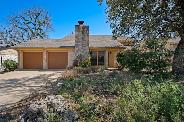 view of front of property featuring a chimney, driveway, an attached garage, and roof with shingles