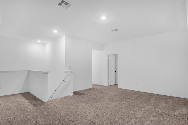 carpeted spare room featuring visible vents, recessed lighting, and baseboards