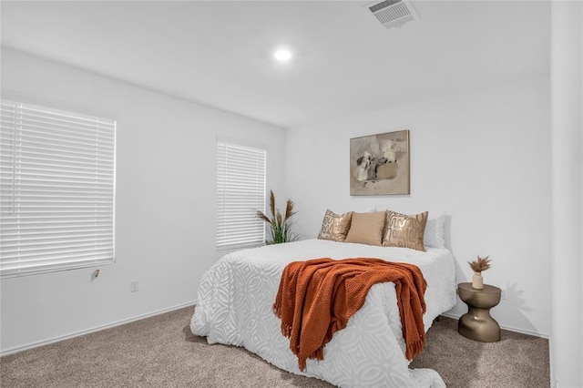 bedroom featuring visible vents and light colored carpet